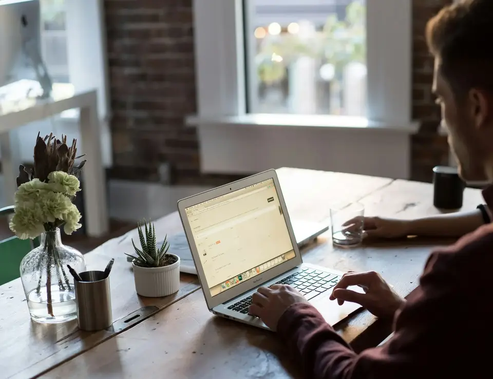a man sitting at a table using a laptop